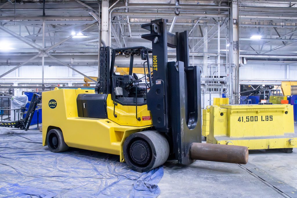 Coil handling lift truck carrying a large metal coil