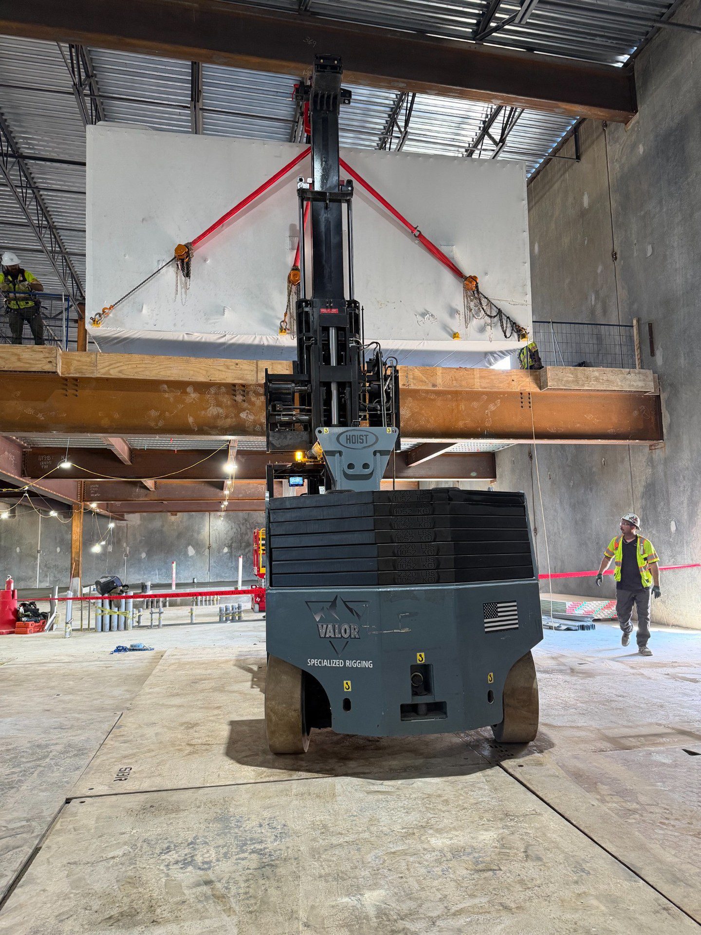 How Valor Specialized Rigging Moved a 15,000 lb Air Handler with a Hoist FR 40/60 Rear view of the Hoist forklift with red slings and chain rigging supporting the wrapped air handler at mezzanine height
